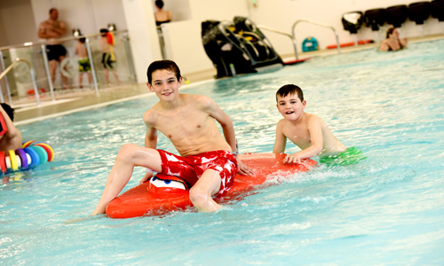 Boys playing on floats at Newark Sports and Fitness Centre pool